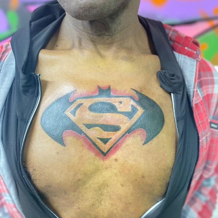Chest tattoo combining Batman and Superman logos